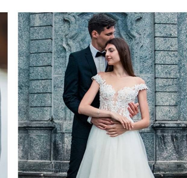 Newlyweds posing by a stone wall