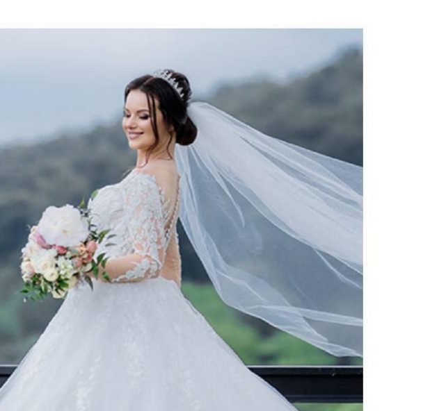 Bride with flowing veil holding peonies